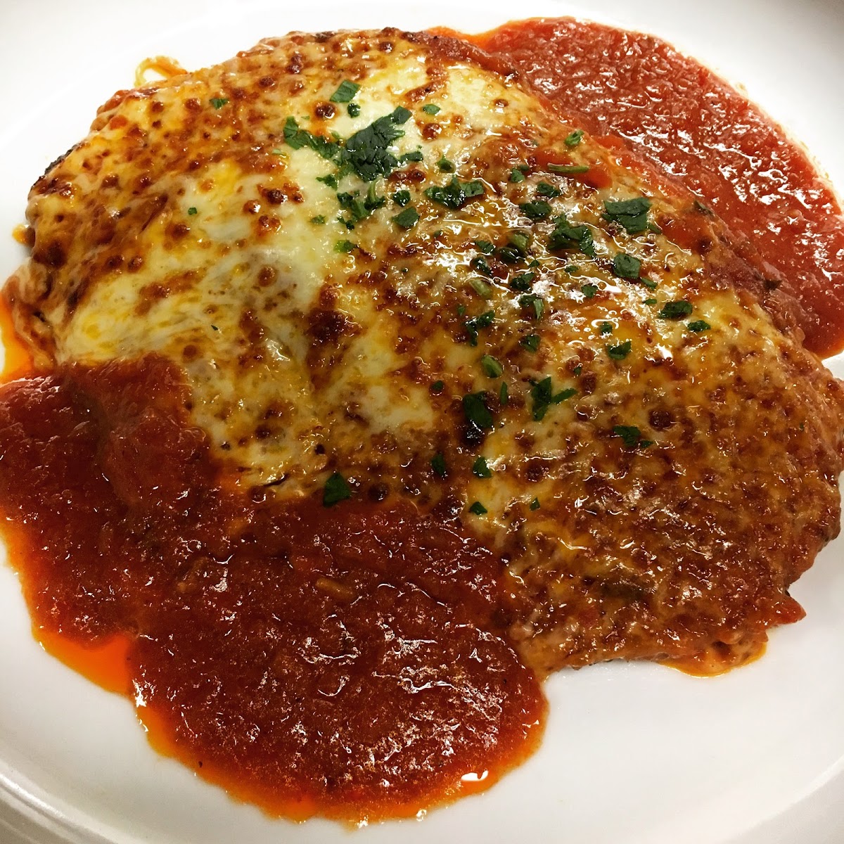 Chicken parmigiana with melted mozzarella in red sauce