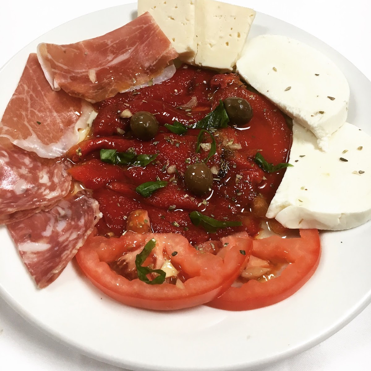 Antipasto plate with prosciutto, mozzarella, roasted peppers and tomatoes